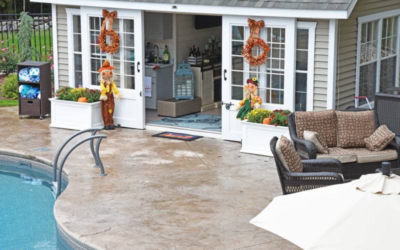 Custom inground pool with small pool house installed by Majestic Pools